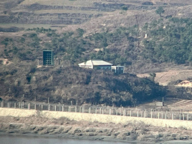 南北軍事境界線がある川沿いの北朝鮮側に設置してあるスピーカーと思われる緑色の構造物（左側）＝11月24日、韓国北西部・坡州市（撮影・山口卓）