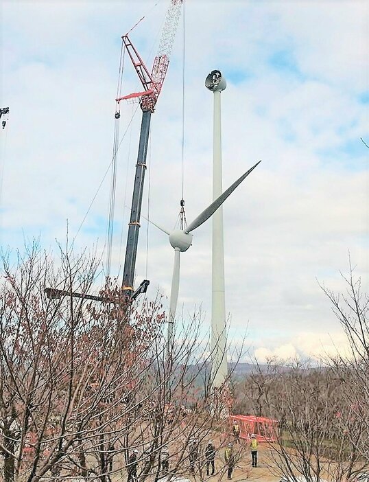 支柱から取り外され、大型クレーンでつるされる風車のプロペラ＝小矢部市の稲葉山山頂