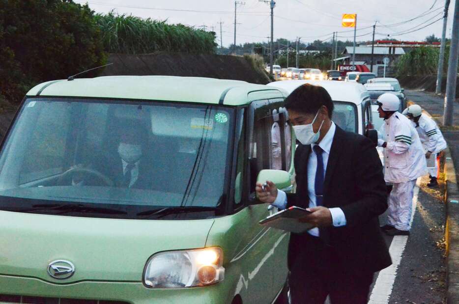 発生時間帯に合わせ現場付近で検問する徳之島署員ら＝２１日午後５時半ごろ、伊仙町佐弁