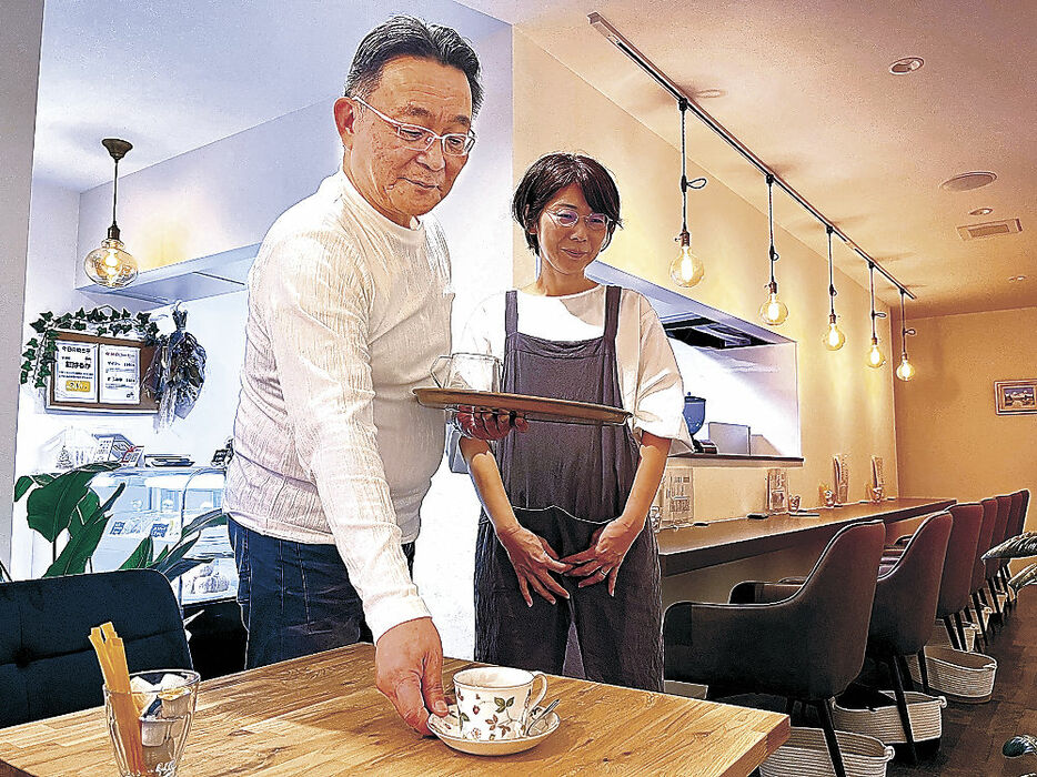 オープンした喫茶店「スリー・アローズ」で接客する小村さん夫妻＝金沢市涌波１丁目