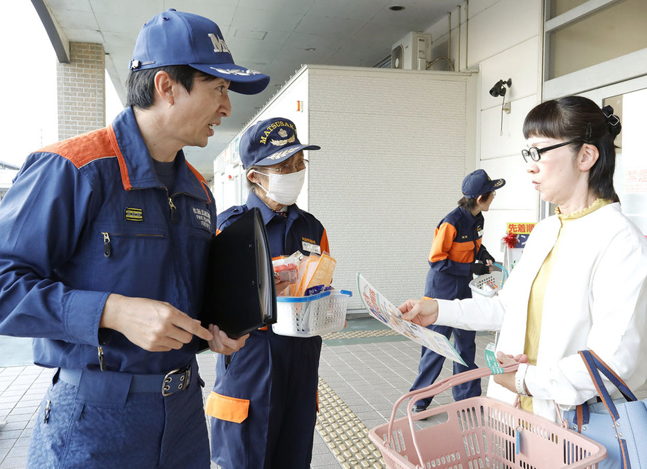 消防隊員から啓発チラシを受け取る買い物客＝川井町のマックスバリュ川井町店で