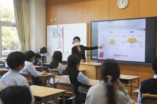 【お金の増やし方について話す久松支店長＝桑名市野田の津田学園小学校で】