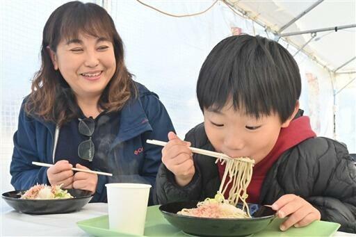 丸岡藩誕生400年記念のそば皿に盛られたおろしそばをすする来場者=11月23日、福井県坂井市丸岡町霞町3丁目