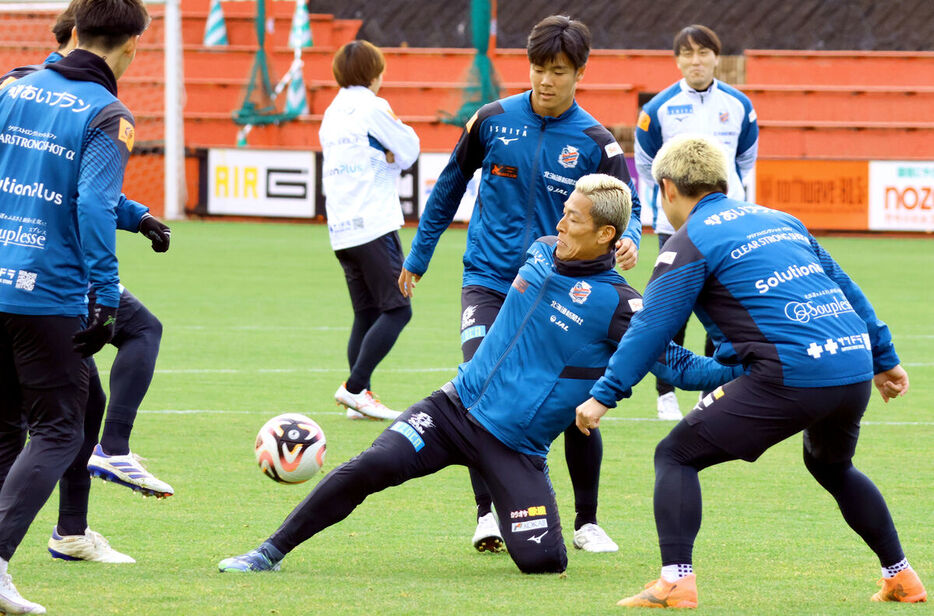 スライディングでボールを奪いに行く札幌・菅野（中央手前＝カメラ・砂田　秀人）