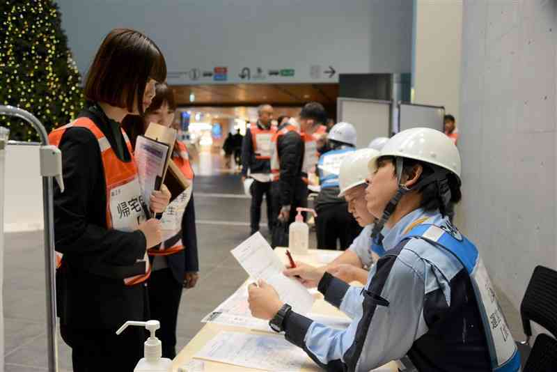 帰宅困難者の受け入れ訓練で、健康状態を確認する熊本城ホールなどの施設職員ら＝18日、熊本市中央区