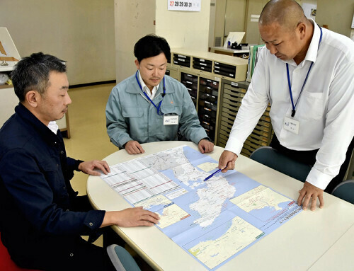 仮設住宅の位置が記された地図の活用法を話し合う石川県七尾市の職員（１０月２１日、同市役所で）