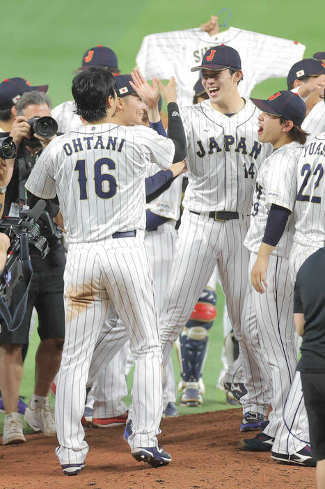 ＷＢＣ優勝の歓喜の輪が解けた後、佐々木朗希（右）とタッチする大谷翔平（１６番）