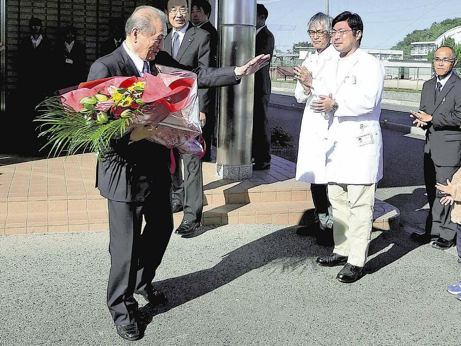 村役場を去る藤本村長（左）（25日午前、大分県姫島村で）