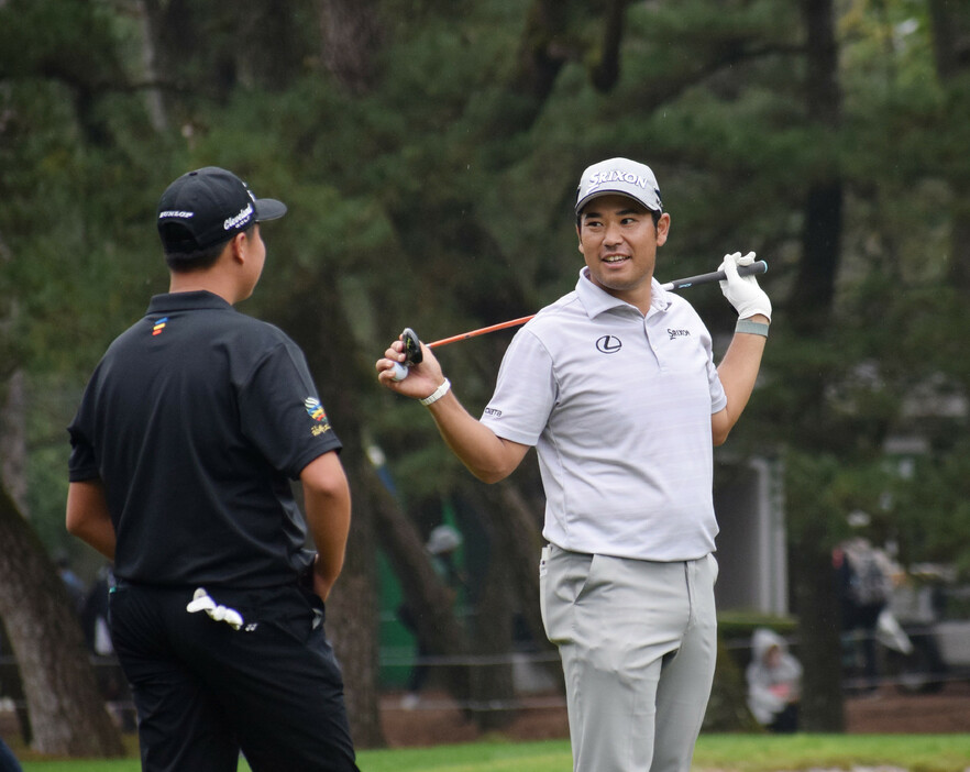 フェニックス男子ゴルフ。プレー中に松山茉生（左）と談笑する松山英樹＝１５日、宮崎・フェニックスＣＣ