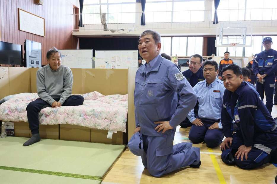 石川県輪島市立鳳至小学校の避難所で、避難者と言葉を交わす石破茂首相（中央）＝１０月５日