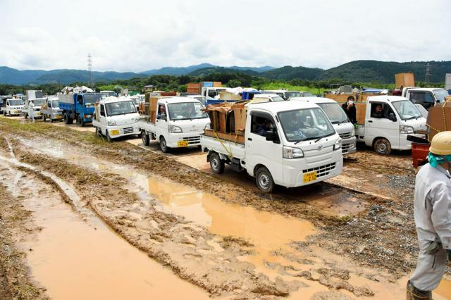 2020年の熊本豪雨では、災害ごみの仮置き場に軽トラックが列をつくった=同年7月8日午後0時58分、熊本県人吉市上漆田町、神野勇人撮影