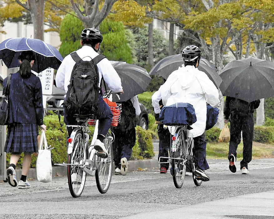 ヘルメットをかぶって登校する熊毛南高の生徒たち（1日午前、山口県平生町で）