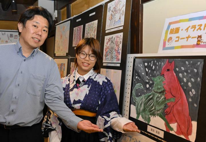 多彩な作品が並ぶアート展をPRする東田さん（右）と新井さん