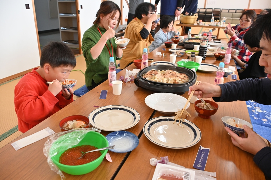 イクラ加工体験で作ったしょうゆ漬けを味わうツアー参加者