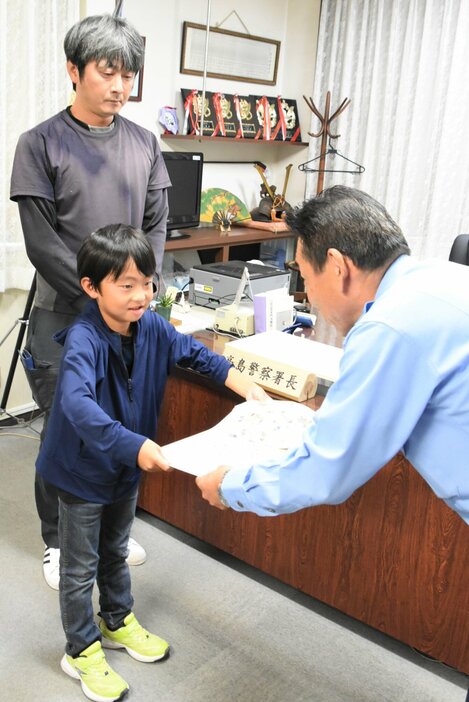 感謝状を受け取る酒井結都さん（中央）と父勝史さん＝高島市・高島署