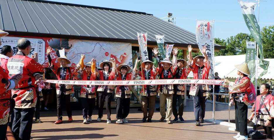 ゴール地点の郡山城跡でテープを切る第11区のメンバー＝奈良県大和郡山市