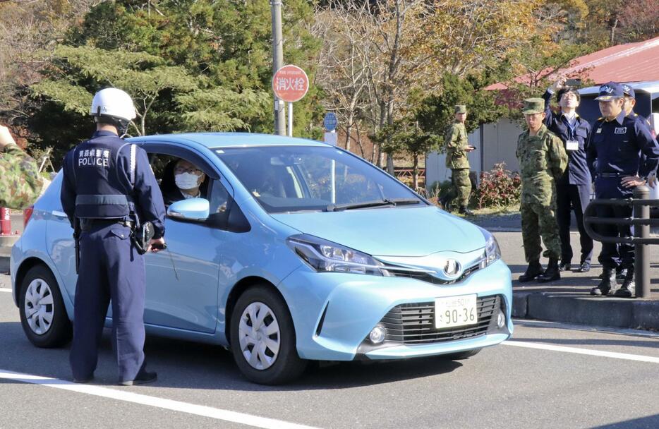 東通原発1号機の重大事故に備えた防災訓練で、国道に合流しようとする車両に乗ったUPZ住民役に自宅で待機するよう促す警察官＝9日午前、青森県東通村