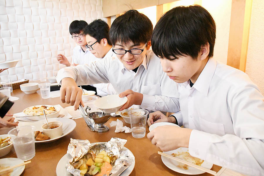 提供されるメニューを試食する飯田東中の生徒たち