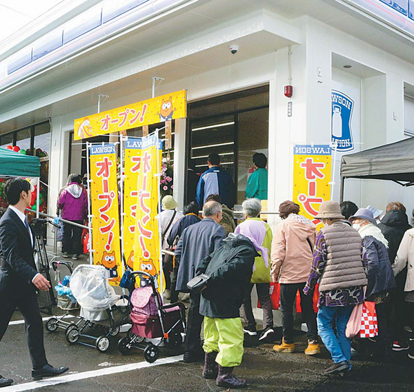 コンビニの店外では地域住民が列をなした（22日、秋田県由利本荘市で）