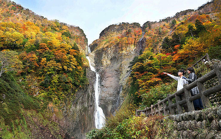 赤や黄色に彩られた称名滝=立山町芦峅寺