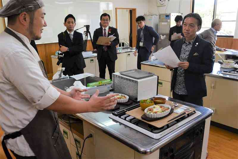 有機野菜を使った焼きカレーを試作した事業者から説明を聞く、ホテル日航熊本の中野省吾総料理長（右）＝13日、山都町