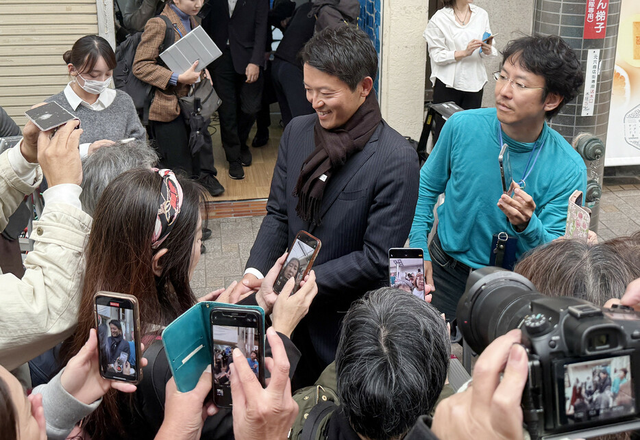 １７日投開票の兵庫県知事選で再選し、支持者らと握手する斎藤元彦氏（中央）＝１８日午後、神戸市中央区