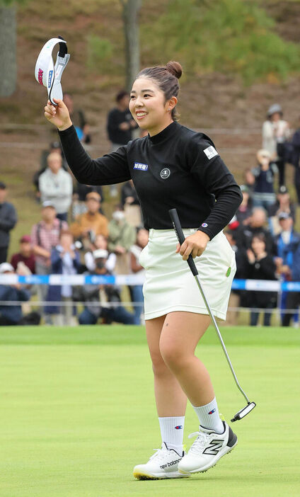 通算２２アンダーで優勝し、笑顔でギャラリーの歓声に応える山下（カメラ・馬場　秀則）