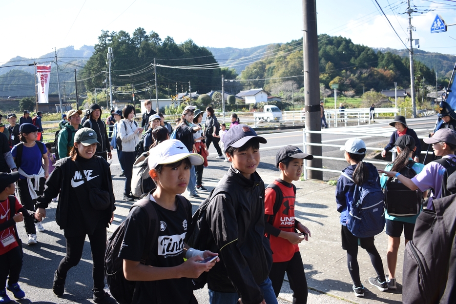 秋晴れの下、思い思いのペースで歩く参加者=岡山県津山市で