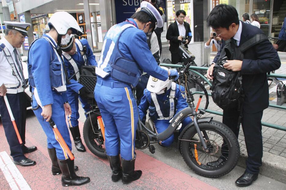 モペットの取り締まりをする警視庁の警察官ら＝1日午後、東京都新宿区