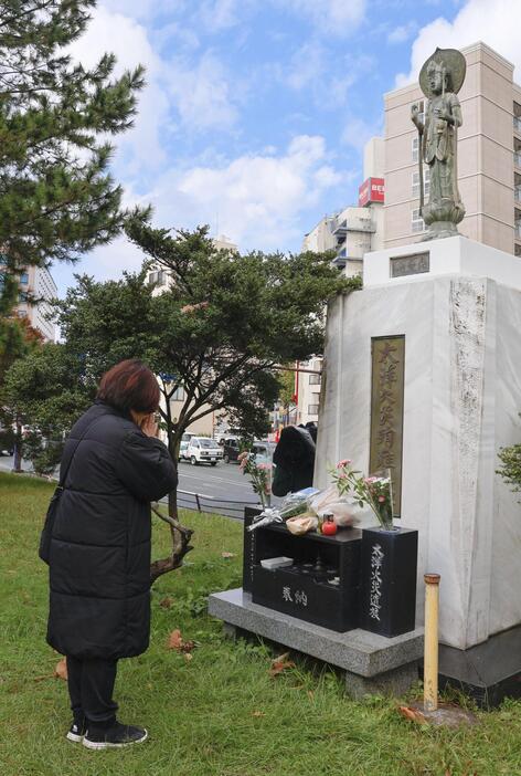 大洋デパート火災から51年となり、慰霊碑に手を合わせる原田真羊さん＝29日、熊本市