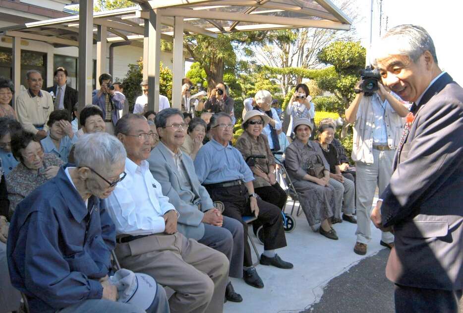 鹿屋市の星塚敬愛園を訪れ、出迎えた入所者に笑顔でこたえる厚労相時代の尾辻秀久さん（右）＝２００４年１０月