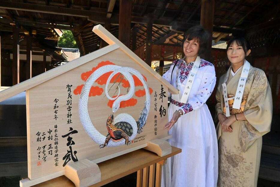 上賀茂神社に絵馬を奉納したニナ・ブチェバさん（左）と書家の今村みづきさん＝京都市北区