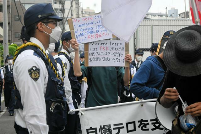 横断幕を掲げてデモ行進をする人たち=2024年5月19日、埼玉県川口市