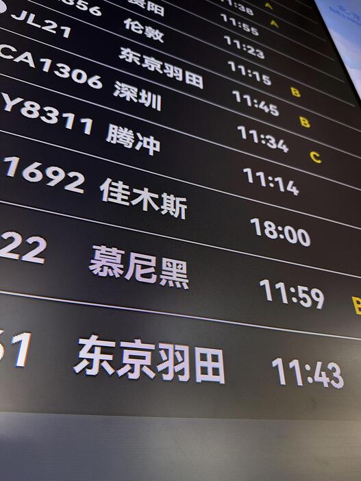 北京首都国際空港の画面に表示された日本からの到着便の情報＝30日（共同）