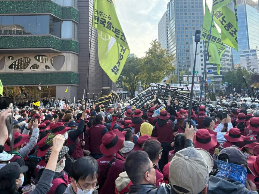 (写真：朝鮮日報日本語版) ▲11月9日午後4時から民主労総・尹錫悦政権退陣運動本部などが開催した「全国労働者大会・1次退陣総決起大会」で、一部の集会参加者が警察の規制線のフェンスを持ち上げている様子。／写真＝読者提供