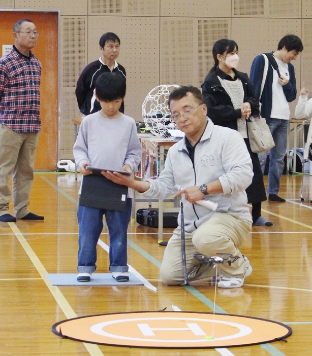 ドローンの操縦に挑戦する子ども（手前左）