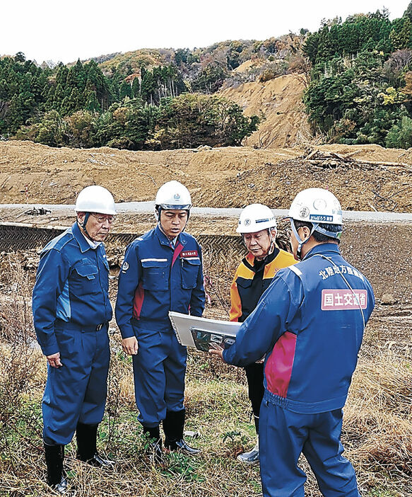 地震、水害の被害や復旧状況の説明を受ける中野国交相（左から２人目）＝２１日午前１０時５０分、珠洲市大谷町