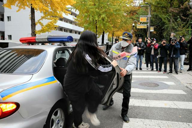 大学修学能力試験の会場にパトカーで送り届けられる受験生=2024年11月14日、ソウル、太田成美撮影