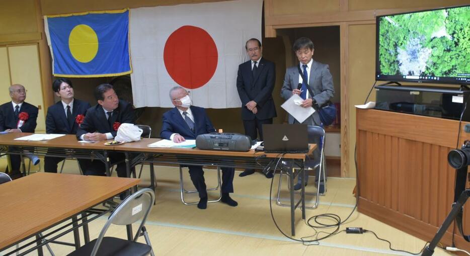 集団埋葬地を撮影した動画を見る影山幸雄会長(右から3人目)ら=水戸市見川