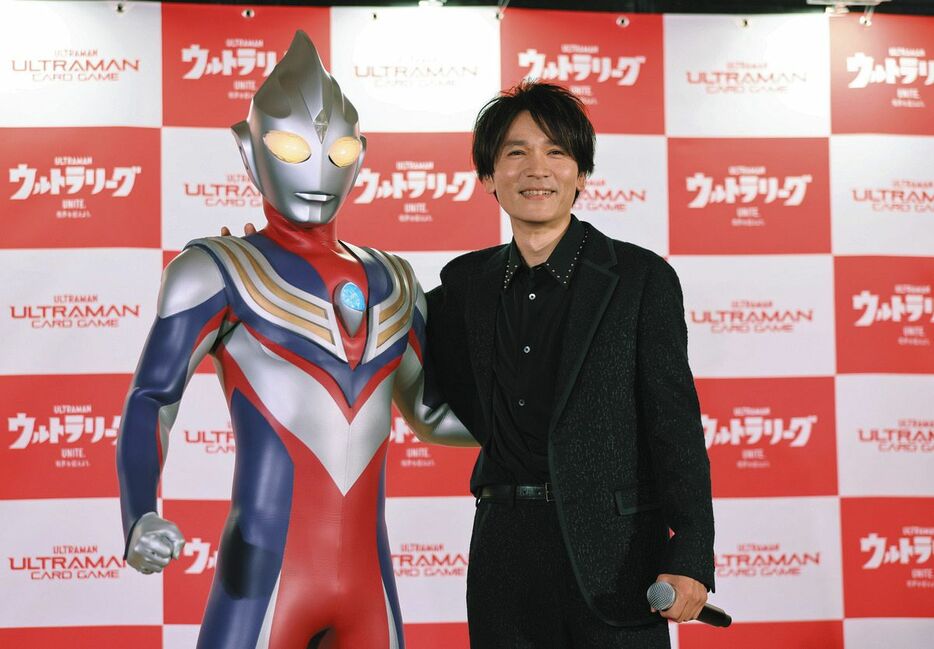 「ウルトラマンカードゲーム」発売開始記念イベントでウルトラマンティガ（左）と笑顔で肩を組む長野博