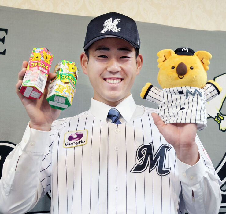 お菓子やハンドパペットを手に笑顔をみせるロッテ育成３位・長島幸佑（カメラ・有吉　広紀）