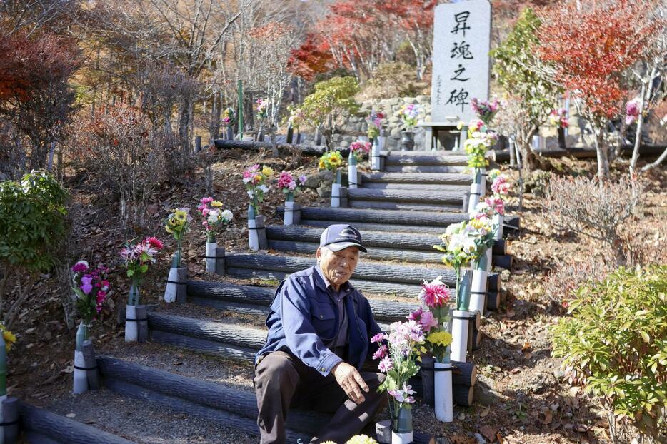 日航機墜落現場「御巣鷹の尾根」の慰霊碑前に造花を供える管理人の黒沢完一さん＝14日、群馬県上野村