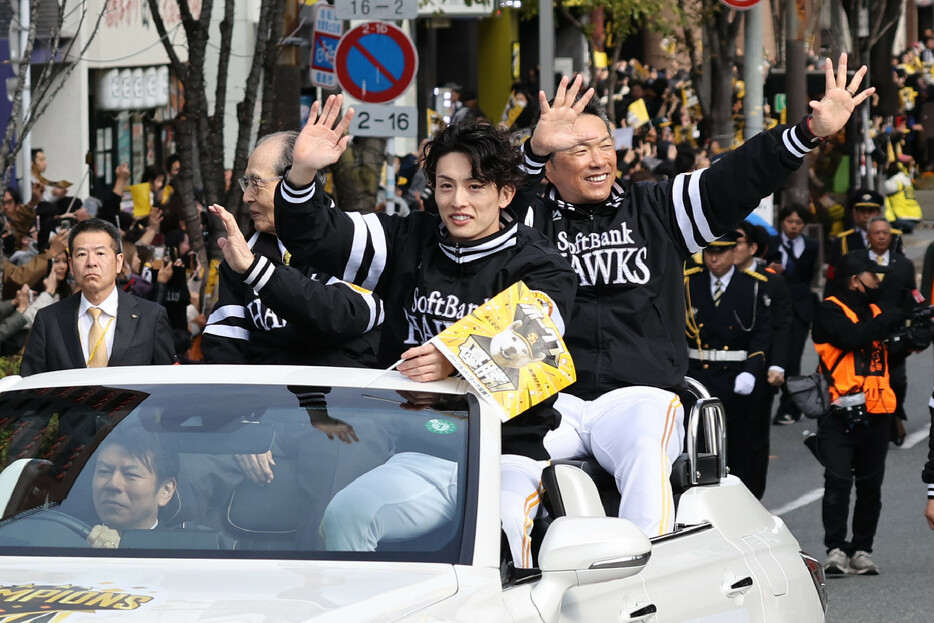 プロ野球パ・リーグを４年ぶりに制覇したソフトバンクの優勝祝賀パレードが２４日、福岡市内で行われた。写真は沿道のファンに手を振る（右から）小久保監督、周東、王貞治球団会長。