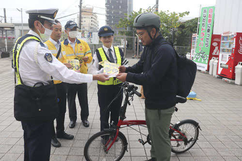 【前川課長（左）からチラシなどを受け取る男性＝桑名市東方で】