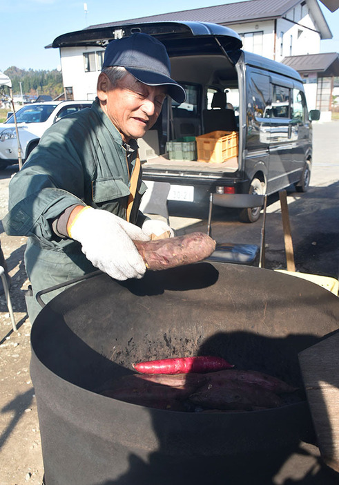 手製のドラム缶の釜で作られる人気の石焼き芋＝村山市富並