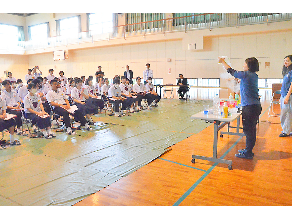 海水にドライアイスを入れて酸性に変える実験に見入る生徒たち＝25日、亀津中学校