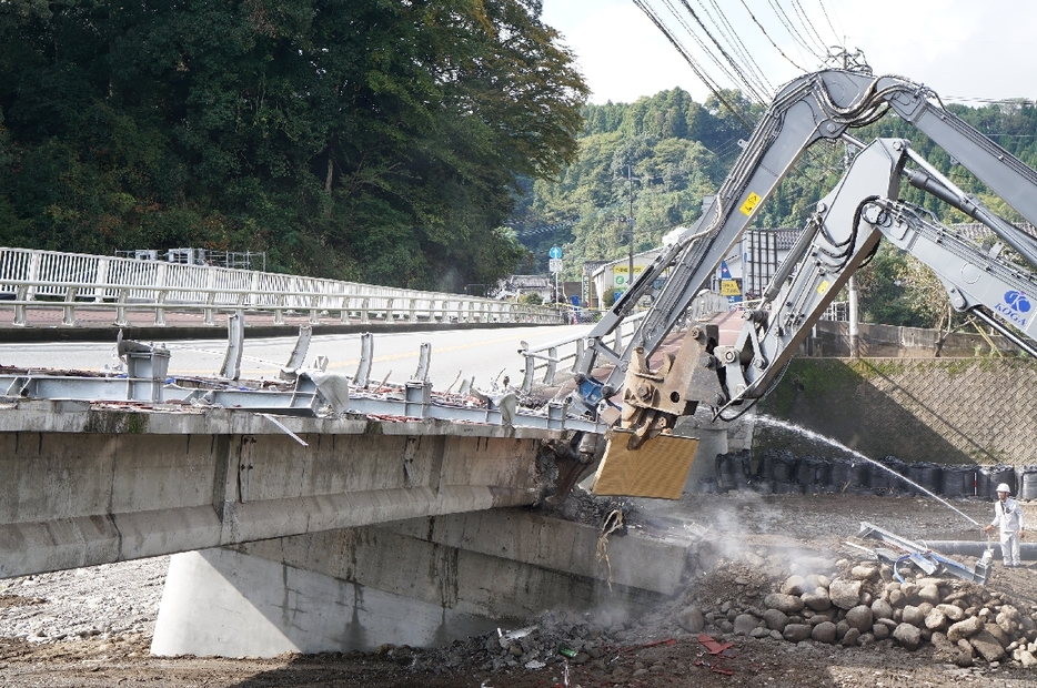 重機を使って傾いた橋の解体工事に着手＝11日午後、日田市友田の三郎丸橋