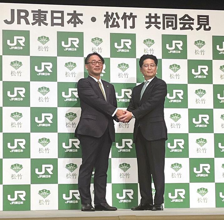 記者会見で握手する、JR東日本の喜勢陽一社長（左）と松竹の高橋敏弘社長＝18日午後、東京都中央区