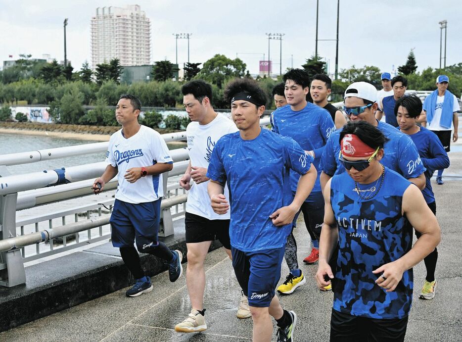 海岸沿いをランニングする福永（中央）ら