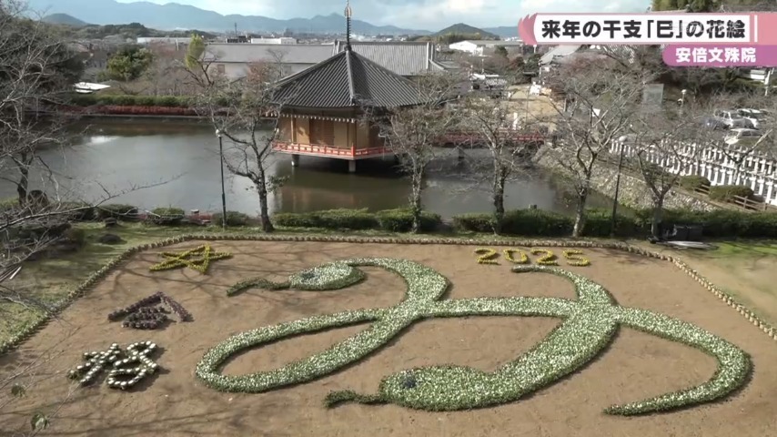 縁起が良いとされる白ヘビを、2匹重ねて「み」の文字を表した大きな花絵